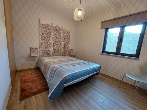 萨布盖鲁Casa do Pátio的一间卧室设有一张床、一个窗口和一张桌子