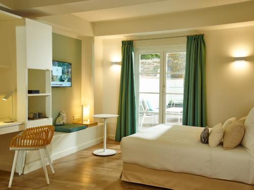 枫丹白露Hôtel de Cavoye的一间卧室配有一张床、一张桌子和一个窗户。