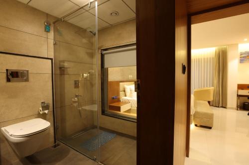 门格洛尔Royal Plaza Suites的一间带卫生间和玻璃淋浴间的浴室
