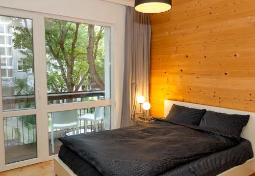 瓦尔纳Bright & Spacious 1BD Apartment with a Charming Balcony的一间卧室设有一张黑色的床和一个窗户。