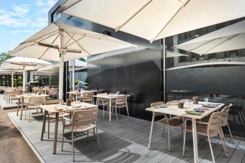 卢森堡INNSiDE by Meliá Luxembourg的一间带桌椅和遮阳伞的餐厅