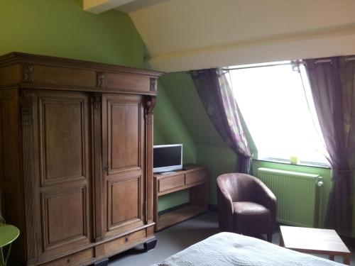 斯帕新城堡酒店的一间卧室设有大型木制橱柜和电视
