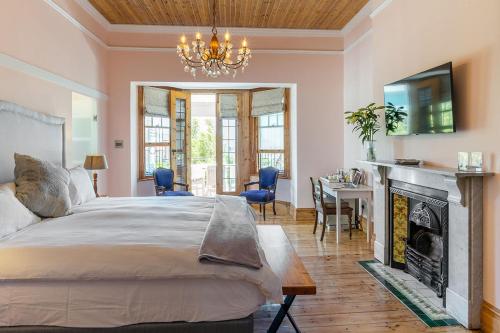 开普敦比安卡别墅住宿加早餐旅馆的一间卧室配有一张床、一个壁炉和一个吊灯。