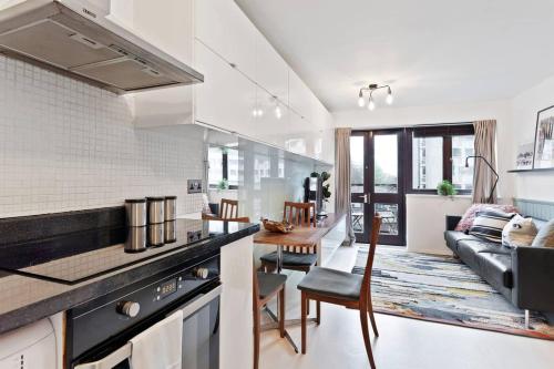 伦敦Modern 2 Bedroom Apartment in Hoxton的厨房以及带沙发和桌子的客厅。