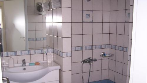 LilikásKomiVillas的白色瓷砖浴室设有水槽和镜子