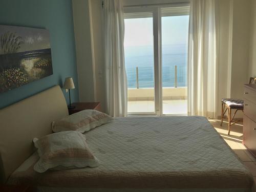 LilikásKomiVillas的一间卧室设有一张床,享有海景