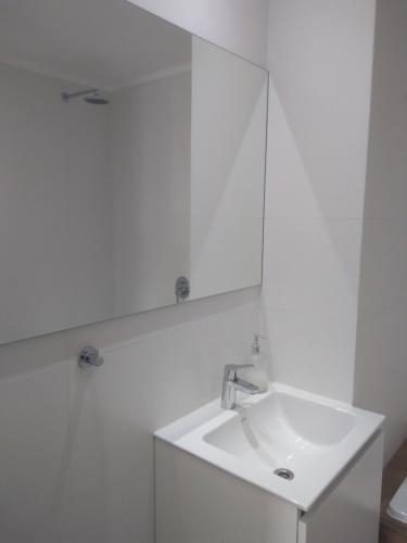 马德普拉塔304 San Lorenzo的白色的浴室设有水槽和镜子