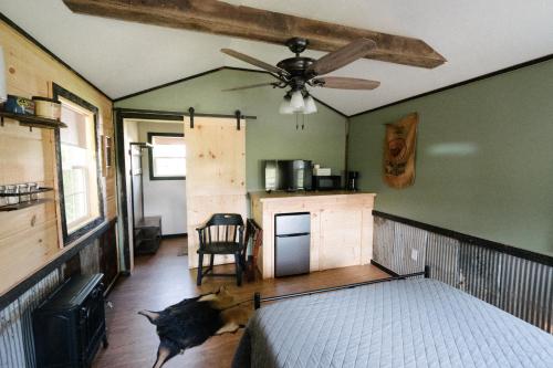 Grand RiversThe Outpost的一间卧室配有一张床和吊扇