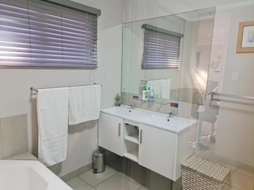 德班Africatamna Self Catering House的白色的浴室设有水槽和镜子