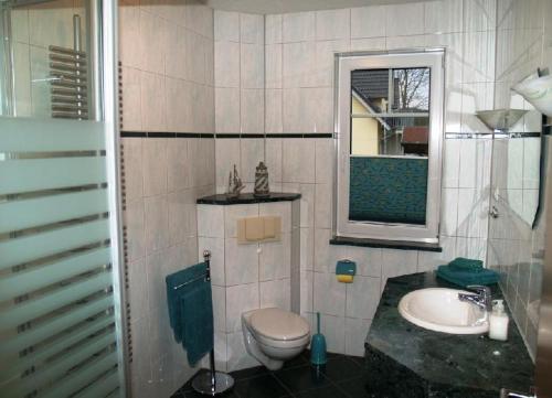 宾茨Ferienhaus-Binz的一间带卫生间、水槽和镜子的浴室