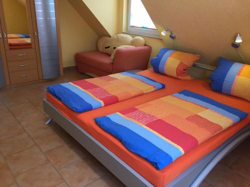 宾茨Ferienhaus-Binz的一间卧室配有一张大床和一把椅子