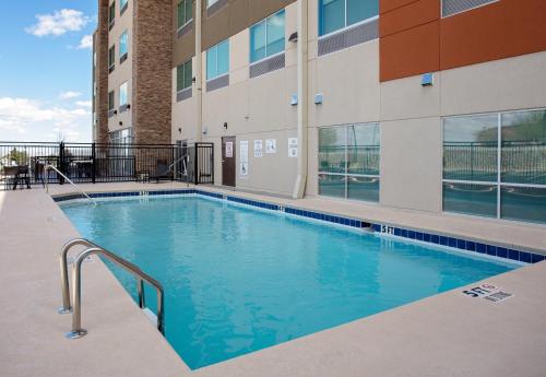 埃尔帕索Holiday Inn Express & Suites - El Paso North, an IHG Hotel的大楼前的游泳池