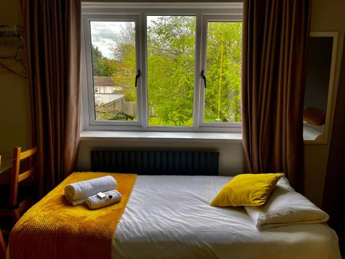 牛津霍利布什宾馆酒店的窗户前的一张床上有两条毛巾