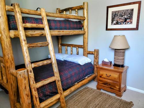 马姆莫斯湖Summit Ski Resort 2BR-2BA, Mammoth Lakes的一间卧室配有一张双层床、一盏灯和一张桌子