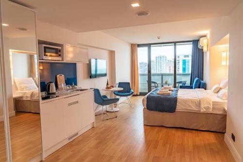 巴统Orbi City Hotel Apartments的酒店客房设有床、厨房和浴室。
