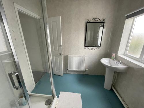 诺里奇Golden Triangle Rooms的一间带水槽、淋浴和镜子的浴室