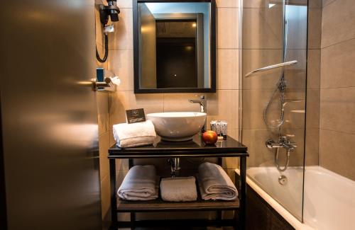 马德里NYX Hotel Madrid by Leonardo Hotels的浴室配有水槽、淋浴和浴缸。