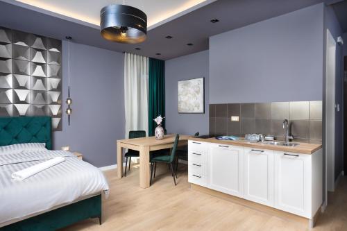 波扎雷瓦茨Hill Apartments的一间带一张床和一张书桌的卧室和一间厨房