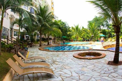 热河市Thermas Paradise Apart的一个带游泳池和棕榈树的度假村