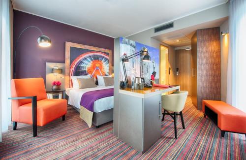 慕尼黑慕尼黑市南莱昂纳多酒店的配有一张床和一张书桌的酒店客房