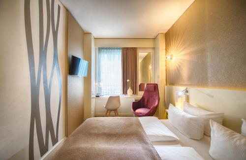 柏林柏林米特莱昂纳多酒店的配有一张床和一把椅子的酒店客房