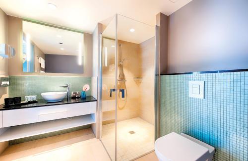 慕尼黑NYX Hotel Munich by Leonardo Hotels的带淋浴、卫生间和盥洗盆的浴室