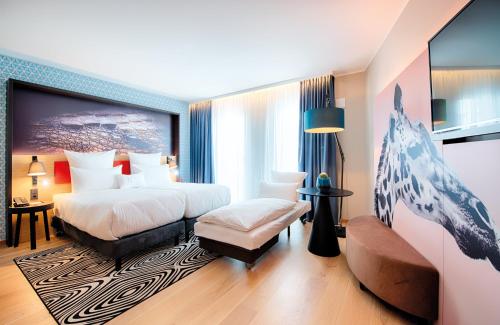 慕尼黑NYX Hotel Munich by Leonardo Hotels的酒店客房,设有两张床和一张沙发