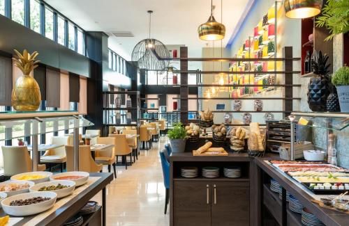 马德里马德里市中心莱昂纳多酒店的餐厅设有桌椅,并展示食物