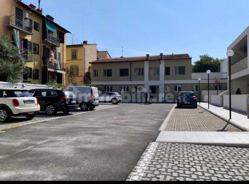 佛罗伦萨Appartamento Careggi con posto auto的一条城市街道,有汽车停在停车场