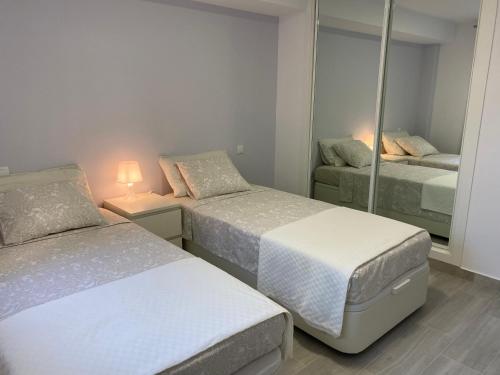 卡博皮诺Nice ground floor apartment- 2 bedrooms - 450 meters from the beach的一间卧室配有两张床和镜子