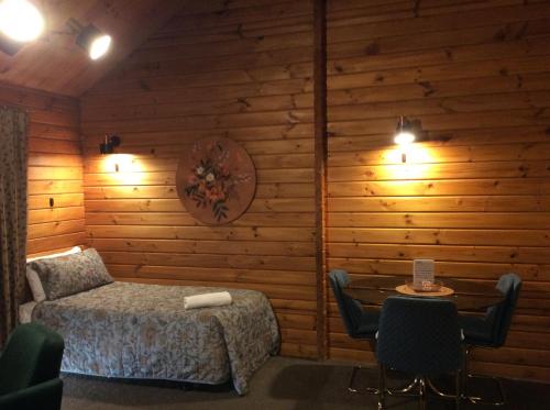 汉默温泉阿尔卑斯汽车旅馆的卧室配有一张床和一张桌子及椅子