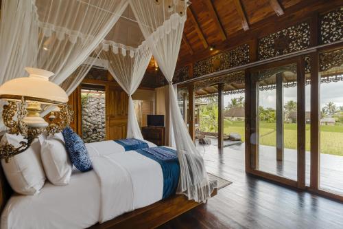 乌布Airsania Ubud Antique Villas的一间卧室配有一张带天蓬的床