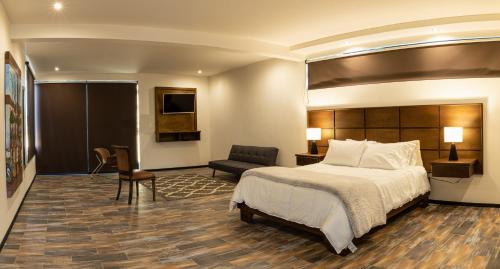 瓜达鲁佩镇Estancias Sierravita的配有一张床和一把椅子的酒店客房