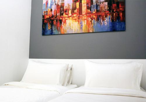马尼拉mySTAY Hotel BGC East的一间卧室设有两张床,墙上挂着一幅画