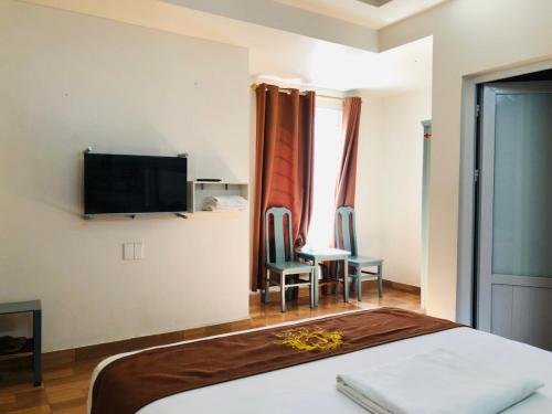 海防科济酒店的酒店客房带一张床、一张桌子和椅子