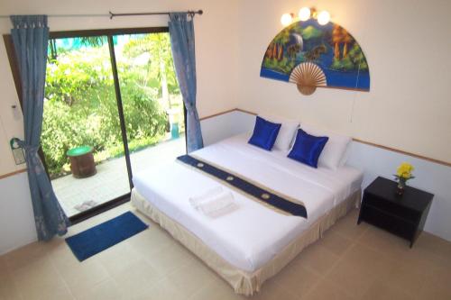 奈扬海滩普吉岛机场夜宿酒店的一间卧室设有两张床和大窗户