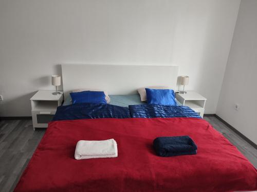 布达佩斯Rákos-patak Family House的一间卧室配有一张带红色毯子的大床