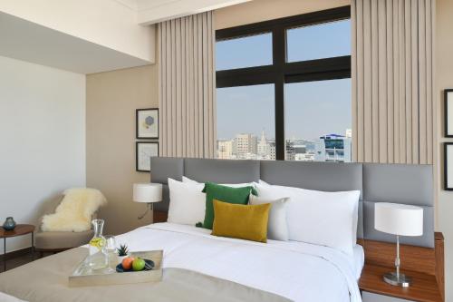 多哈Le Mirage Downtown的卧室配有白色的床和大窗户