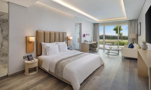 阿吉曼Zoya Health & Wellbeing Resort的一间带白色大床的卧室和一间客厅