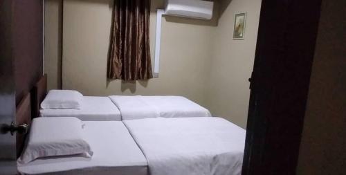 拿笃Tabin Lodge的配有白色床单的酒店客房内的两张床