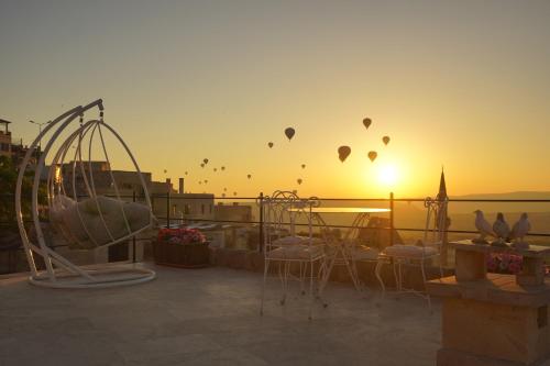乌奇希萨尔Karlık Cave Suite Cappadocia的日落时分天空中一组热气球