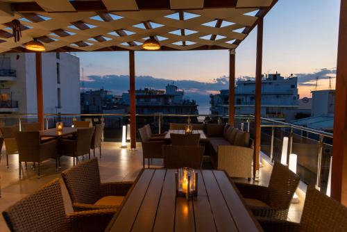 路特奇AGORA luxury BOUTIQUE HOTEL的阳台餐厅,配有桌椅