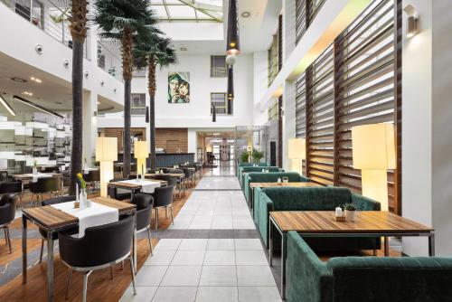 波兹南Hotel Moderno Poznań的餐厅设有绿色的沙发和桌子