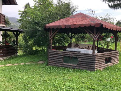 Statjunea BorsaCasa Viorica的草上带屋顶的木制凉亭