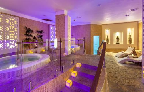 阿德耶阿德赫格瑞考斯塔酒店的浴室设有2个水槽和紫色照明浴缸。