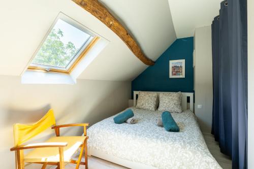 Mon Cottin dans le Vexin的一间卧室配有一张蓝色墙壁的床和一扇窗户
