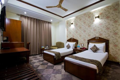 新德里日星大酒店 的酒店客房设有两张床和钢琴