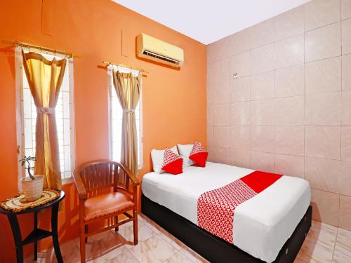 占碑市OYO 91408 Kas Residence Syariah的一间小卧室,配有一张床和一把椅子