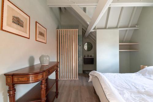 HarelbekeFarmhouse Hoeve Den Ast 5 separate bedrooms with bathrooms的一间卧室配有一张床和一张木桌