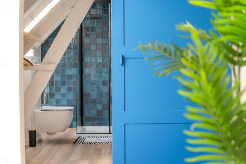 HarelbekeFarmhouse Hoeve Den Ast 5 separate bedrooms with bathrooms的浴室设有蓝色门和卫生间。